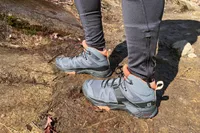Feet in Salomon X Ultra 4 Mid Gore-tex Hiking Boots standing on a rock