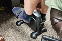 A person pedals the Himaly Mini Exercise Bike