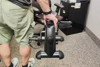 A person holds up the Himaly Mini Exercise Bike