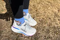 A person wears the Hoka Women's Bondi 9 outside in grass
