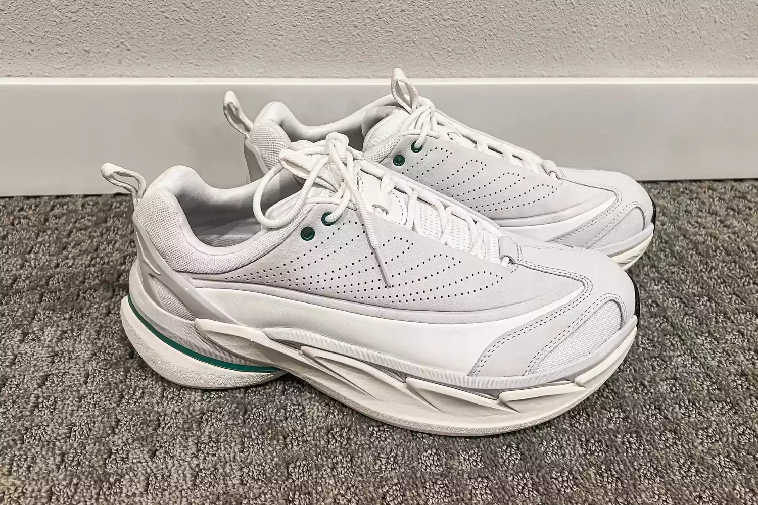 A pair of Hoka All Gender Elevon X Running Shoes on carpet