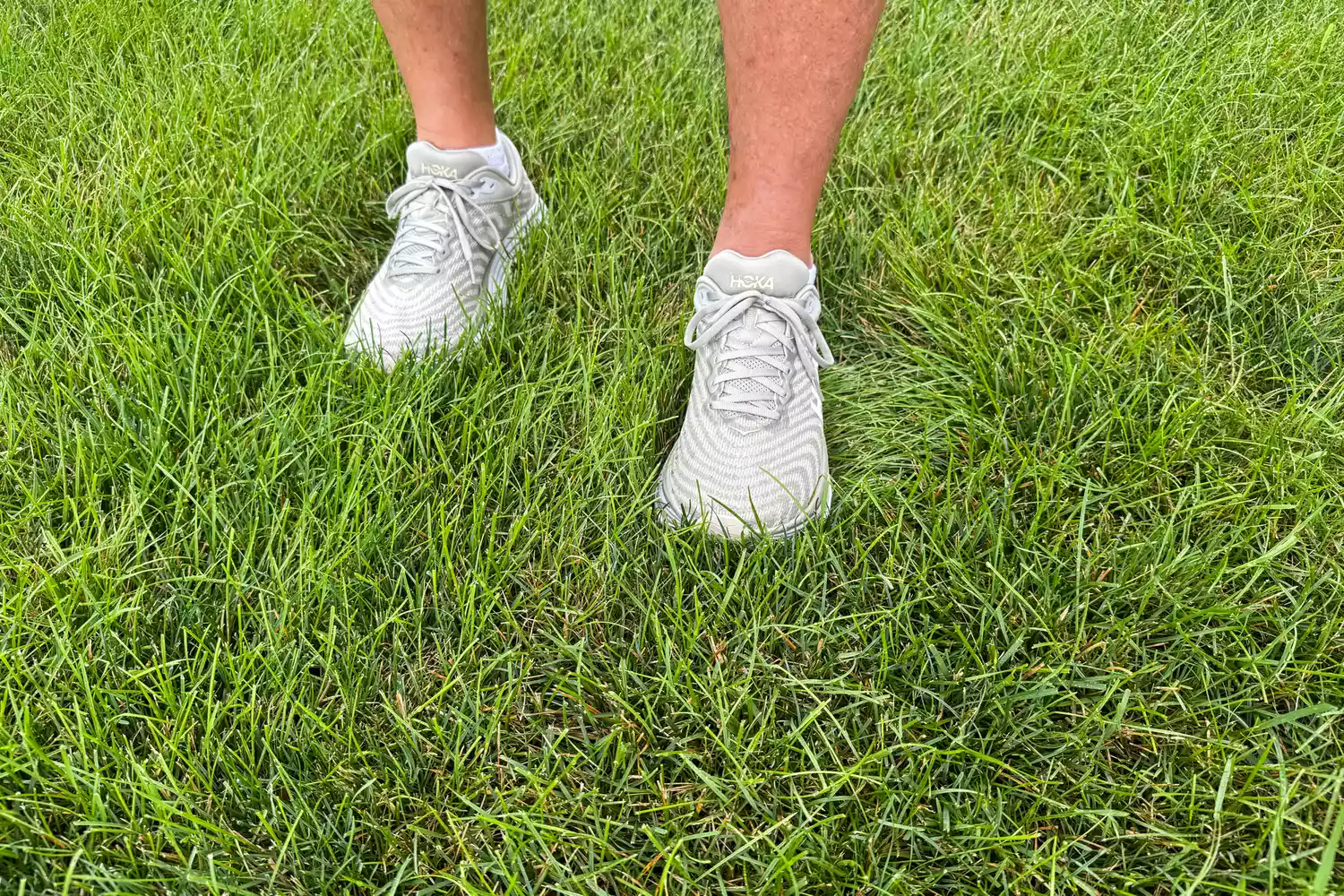 A person walks through grass while wearing the Hoka's Men's Gaviota 5 Running Shoes
