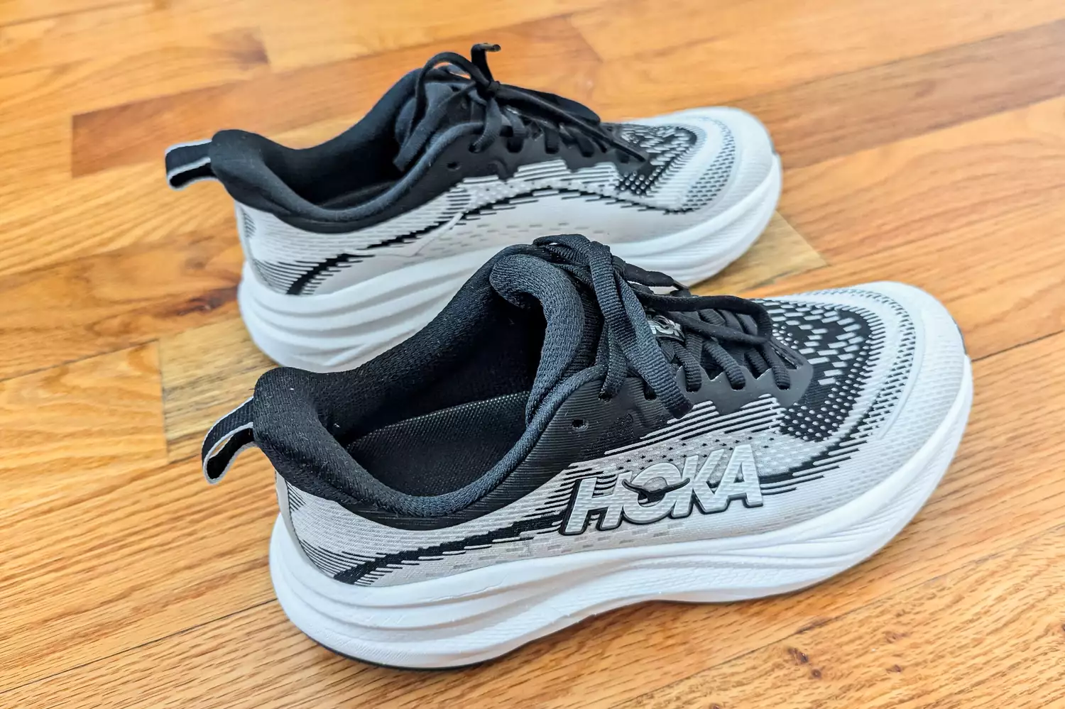A sideview of the Hoka Women's Skyflows on a wooden surface