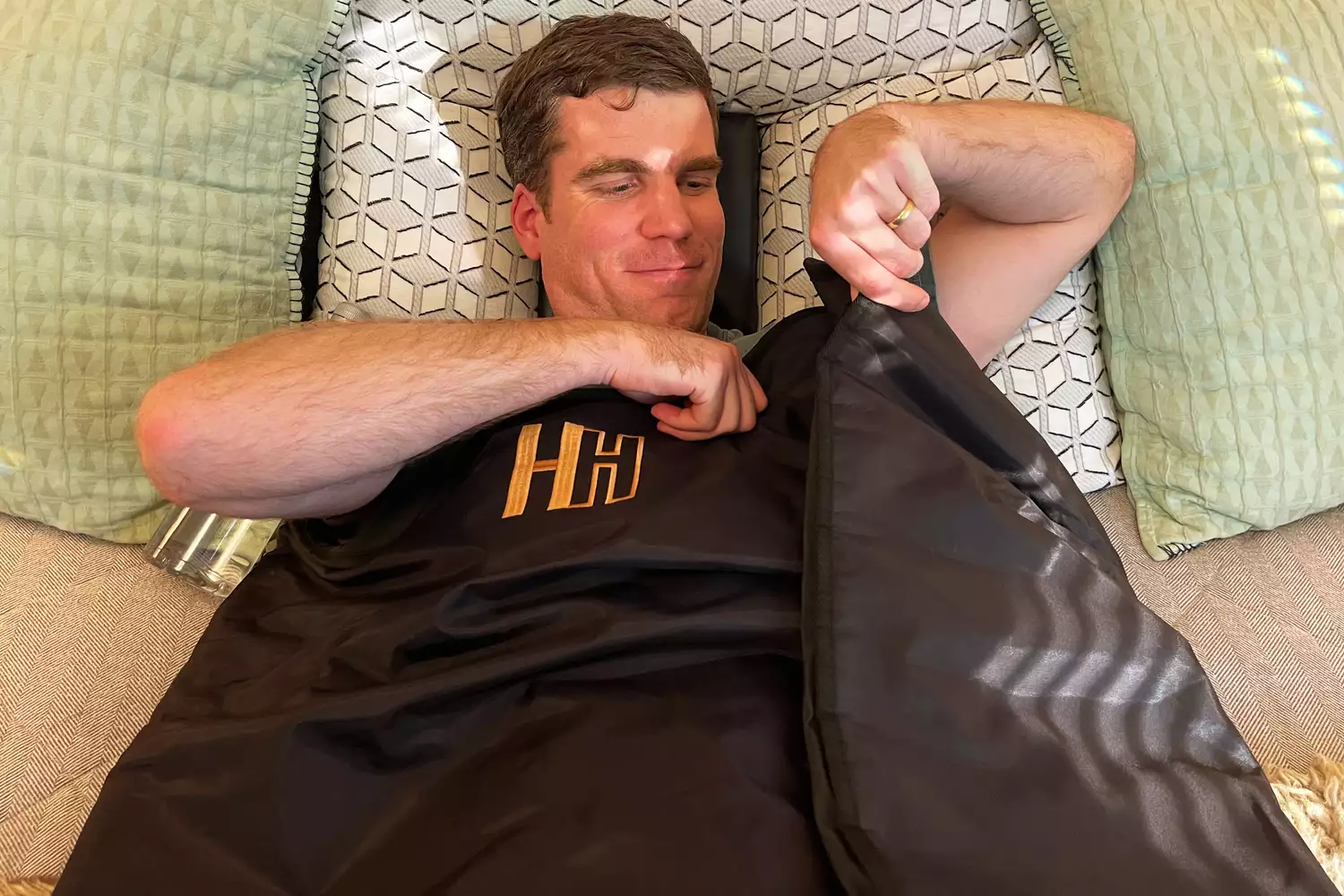 A person laying in the Heat Healer Infrared Sauna Blanket on a bed