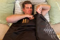 A person laying in the Heat Healer Infrared Sauna Blanket on a bed
