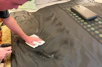 A person cleaning the Heat Healer Infrared Sauna Blanket after use