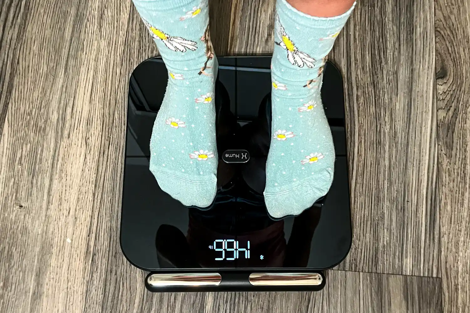 A person stands on the HumeHealth The Body Pod in socks