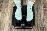 A person stands on the HumeHealth The Body Pod in socks