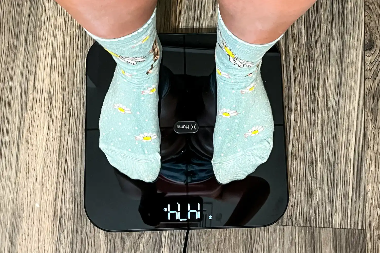 A person stands on the HumeHealth The Body Pod