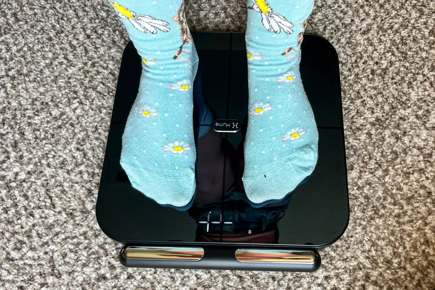 A person stands on the HumeHealth The Body Pod in socks