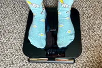 A person stands on the HumeHealth The Body Pod in socks