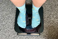 A person stands on the HumeHealth The Body Pod in socks