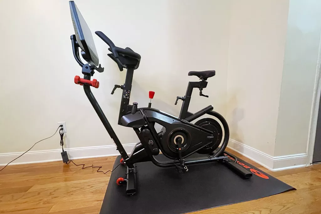 Bowflex VeloCore Bike on a mat over a wooden floor
