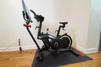 Bowflex VeloCore Bike on a mat over a wooden floor