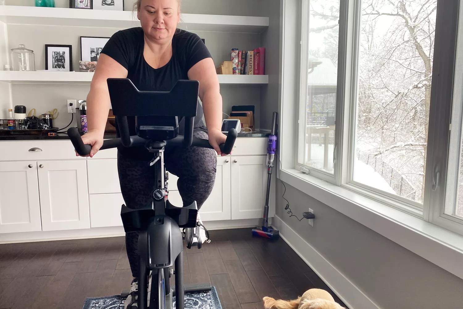 Person riding the Horizon 7.0 IC Indoor Cycle next to a window in living area