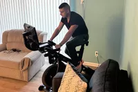 Person riding the NordicTrack Commercial S15i Studio Cycle in between two sofas