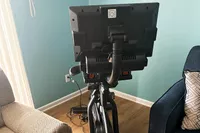 NordicTrack Commercial S15i Studio Cycle set up on a wood floor in between two sofas