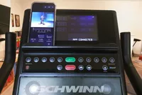 A phone propped up over the screen of the Schwinn Upright Bike Series