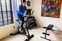 A woman using the Schwinn Upright Bike Series in an exercise room