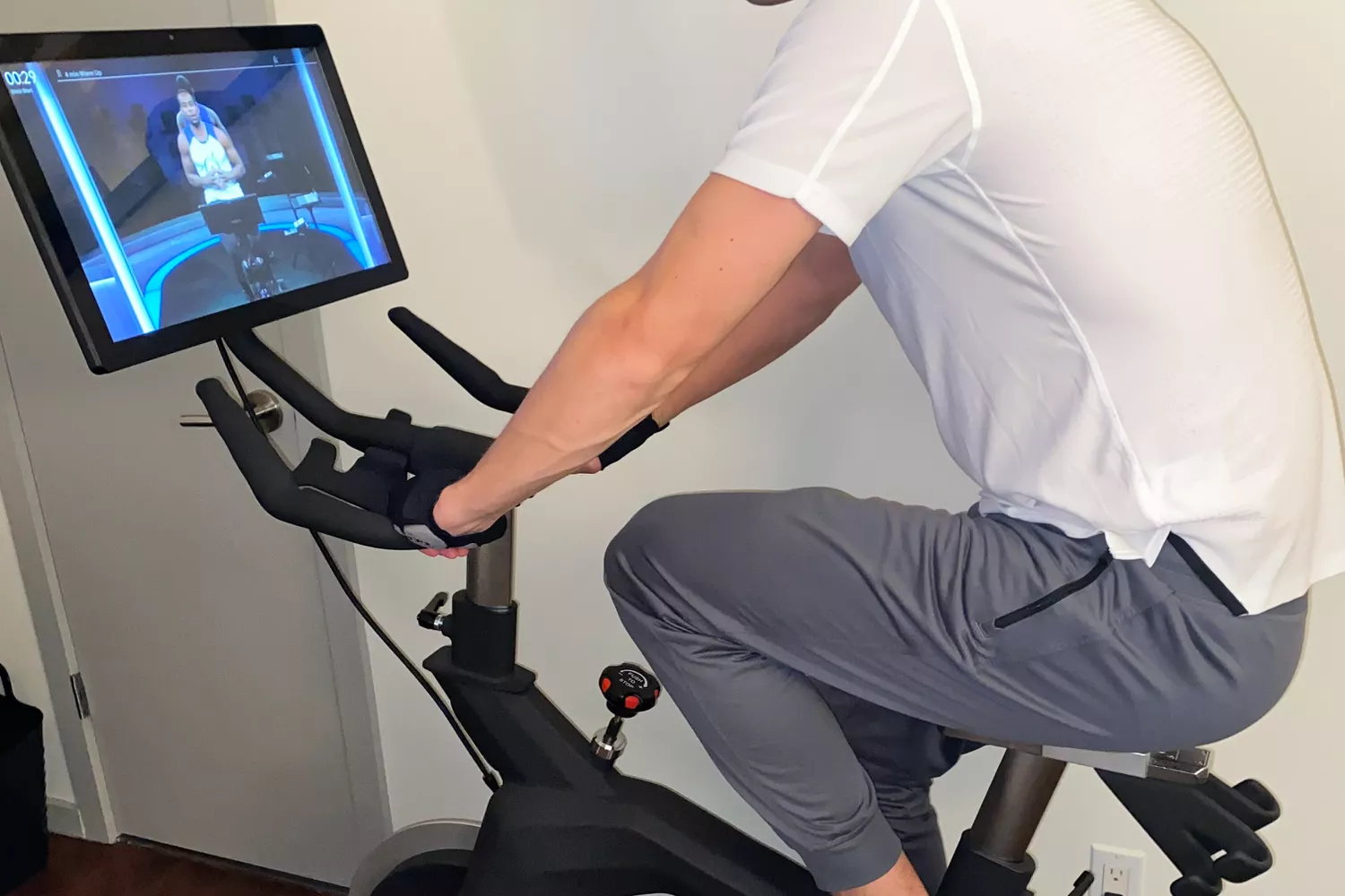 Person riding the Stryde The Bike with trainer on screen