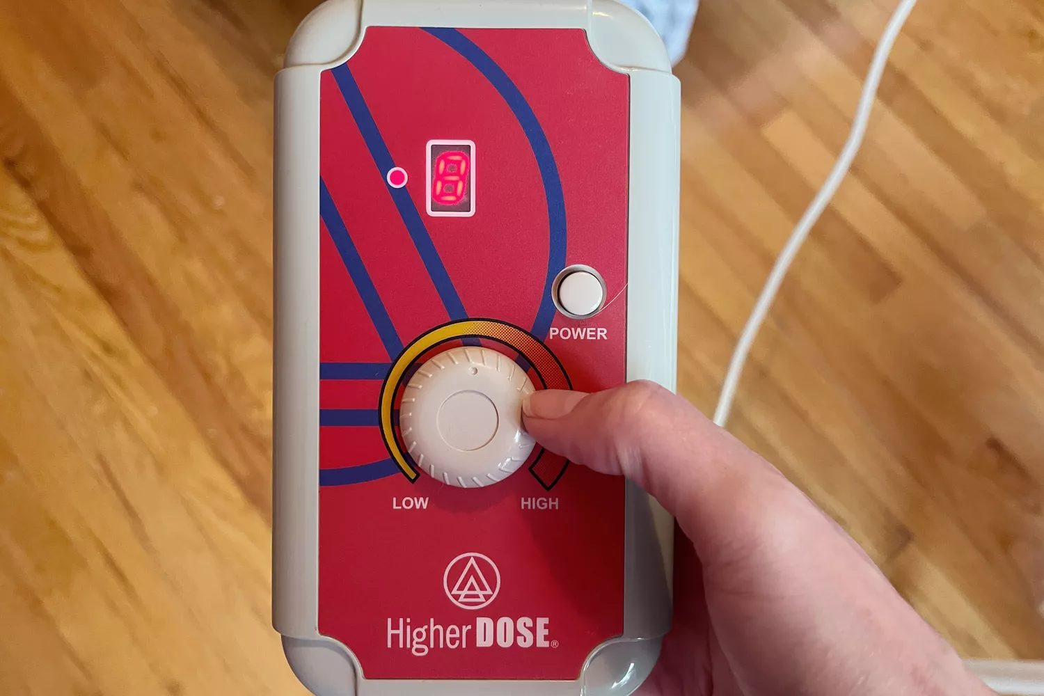 Hand holding the controls for the HigherDose Infrared Sauna Blanket