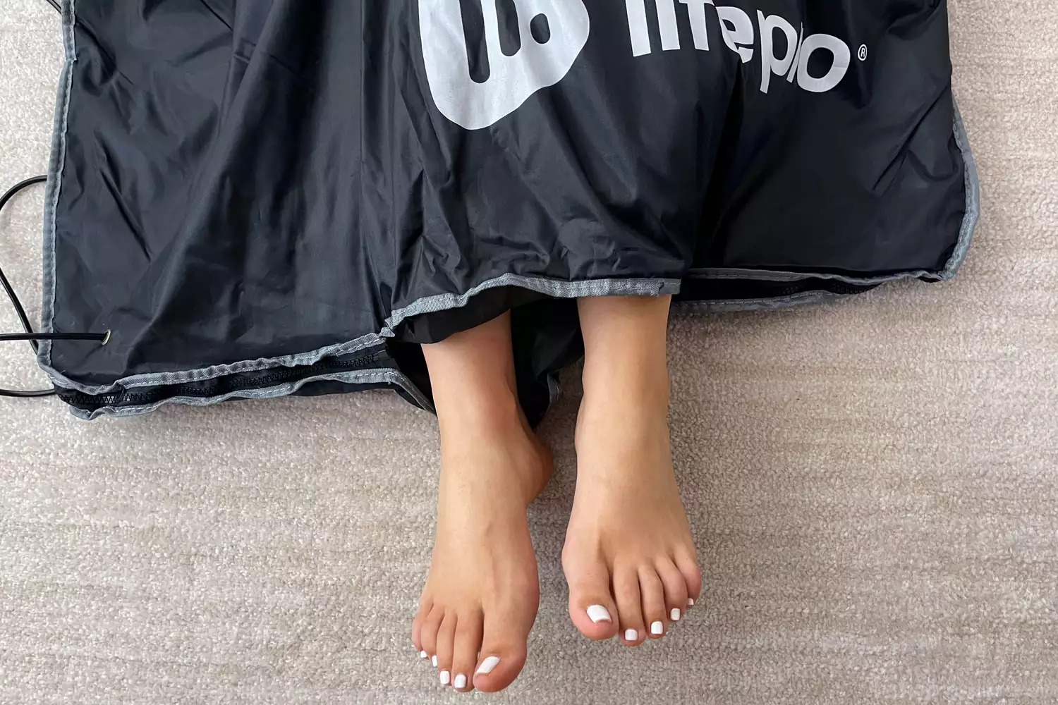 A person's feet stick out of the LifePro BioRemedy Infrared Sauna Blanket