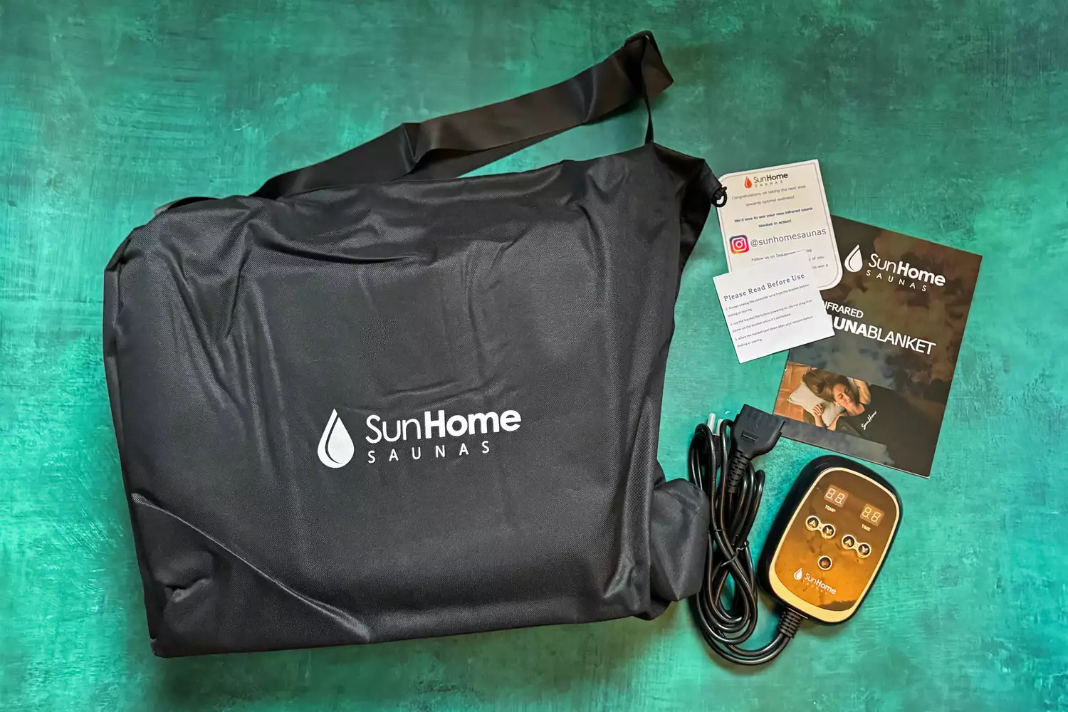 Sun Home Saunas Infrared Sauna Blanket and parts sitting on a green surface