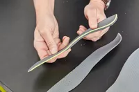 Hands holding half of a Superfeet Run Support Low Arch Shoe Insert