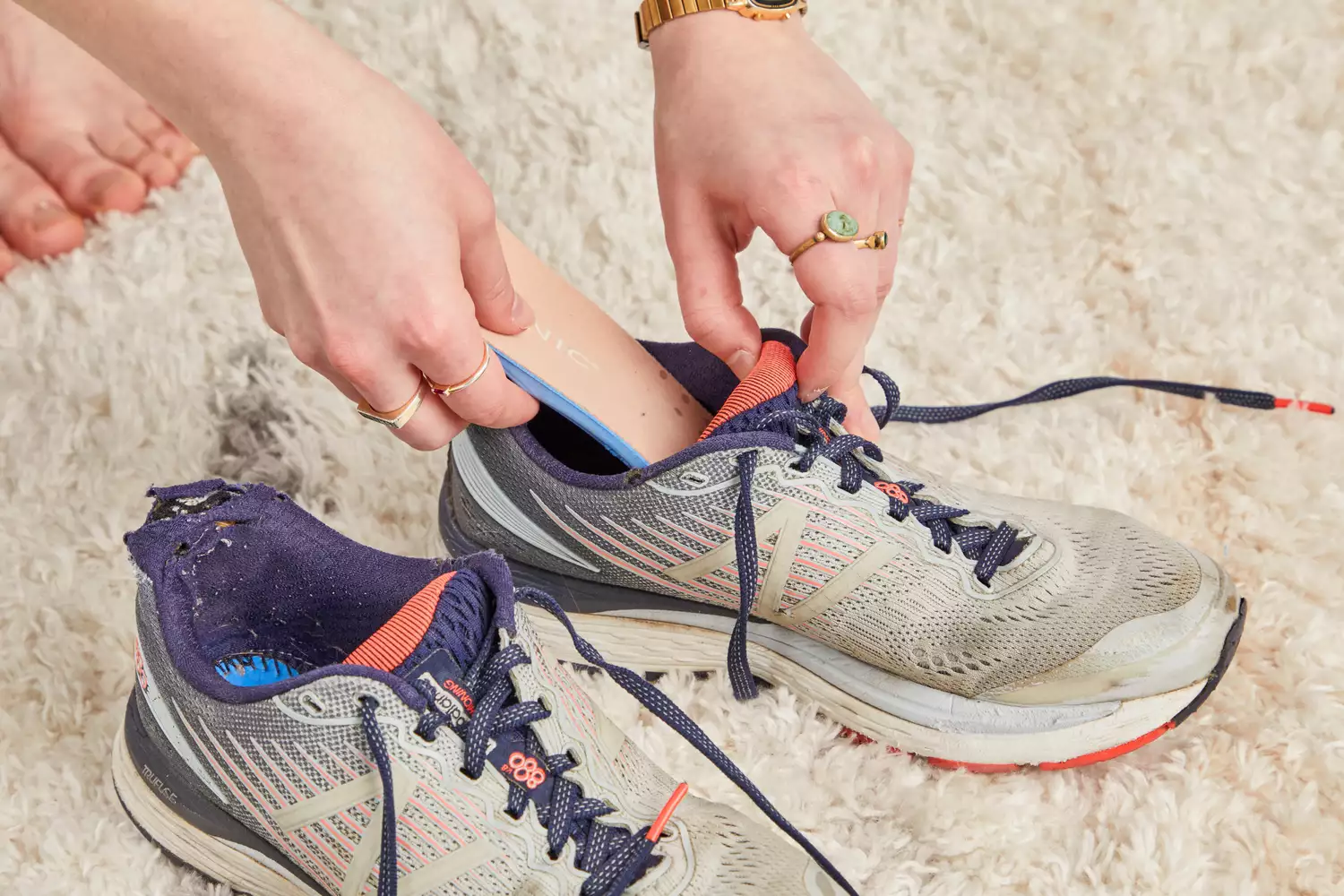 Hand putting a Vionic Slimfit Orthotic Insole into a sneaker