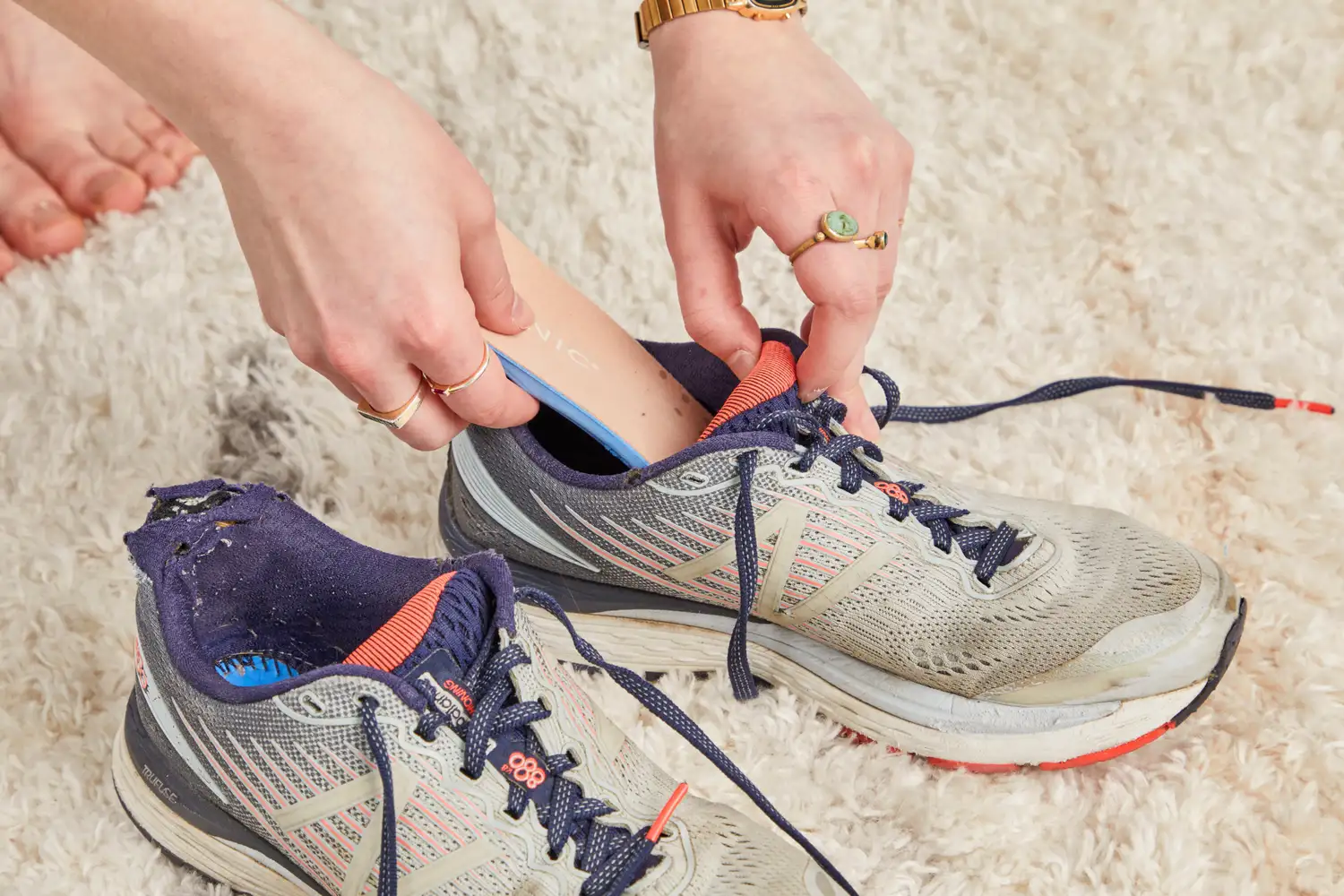 Hand putting a Vionic Slimfit Orthotic Insole into a sneaker