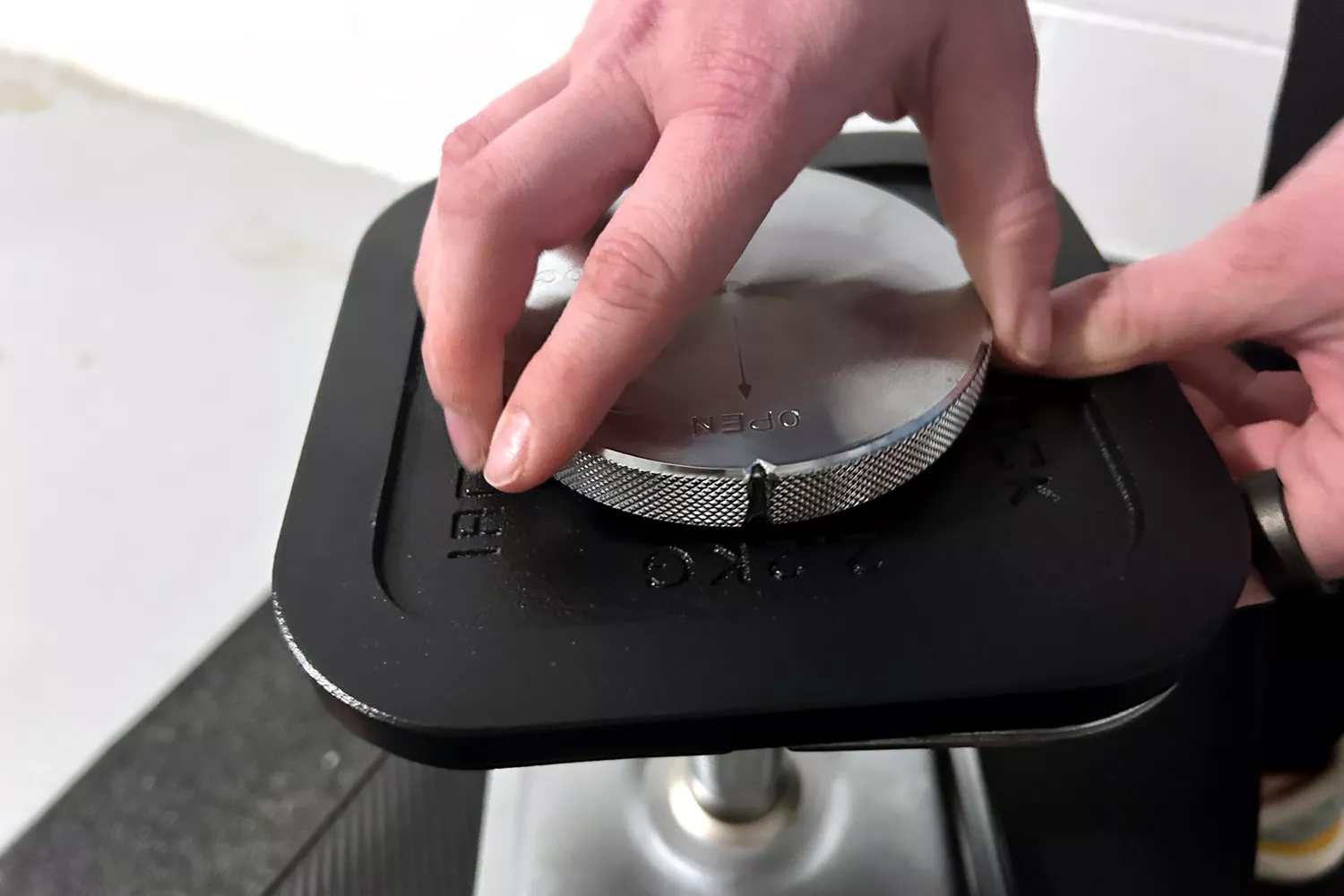 A person assembles the Ironmaster Quick-Lock 75 lb Adjustable Dumbbell System Set