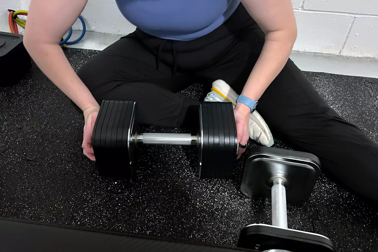 A person assembles the Ironmaster Quick-Lock 75 lb Adjustable Dumbbell System Set