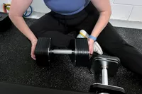 A person assembles the Ironmaster Quick-Lock 75 lb Adjustable Dumbbell System Set