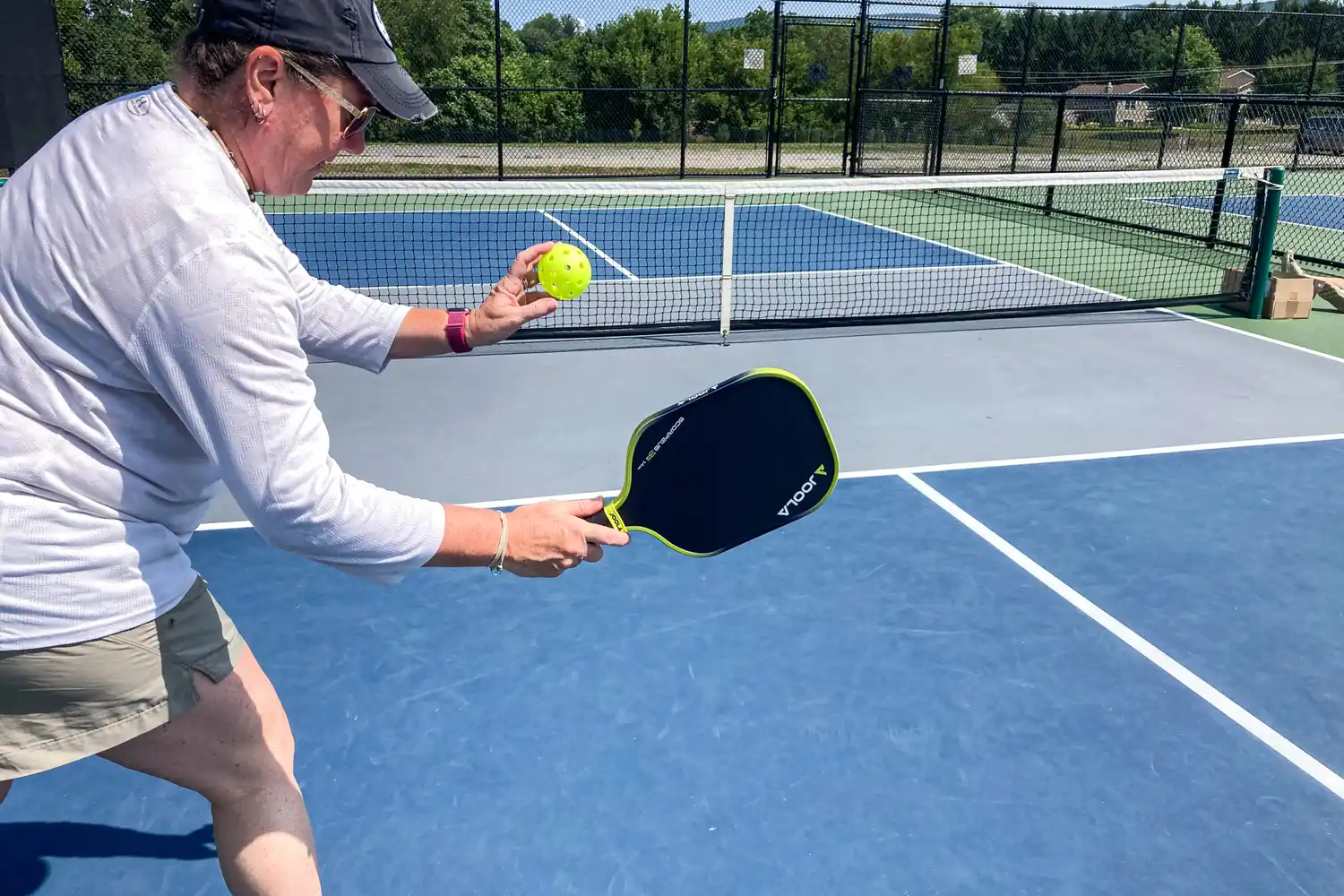 A person hits a pickleball with the JOOLA Anna Bright Scorpeus 3S 14mm Pickleball Paddle