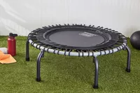 JumpSport 350 Indoor Fitness Trampoline displayed on grass next to water bottle and ball