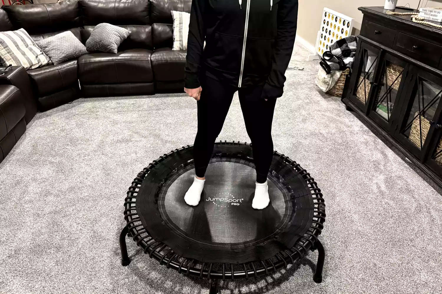 A person stands on the JumpSport 550f 44-Inch Pro Rebounder Trampoline