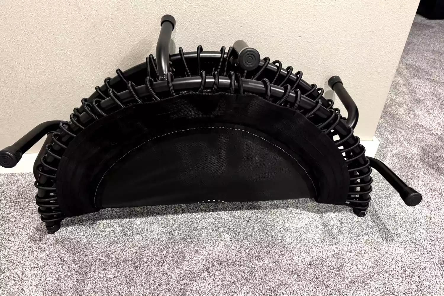The JumpSport 550f 44-Inch Pro Rebounder Trampoline folded and leaning against a wall