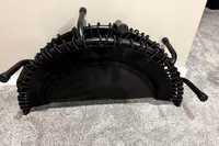 The JumpSport 550f 44-Inch Pro Rebounder Trampoline folded and leaning against a wall