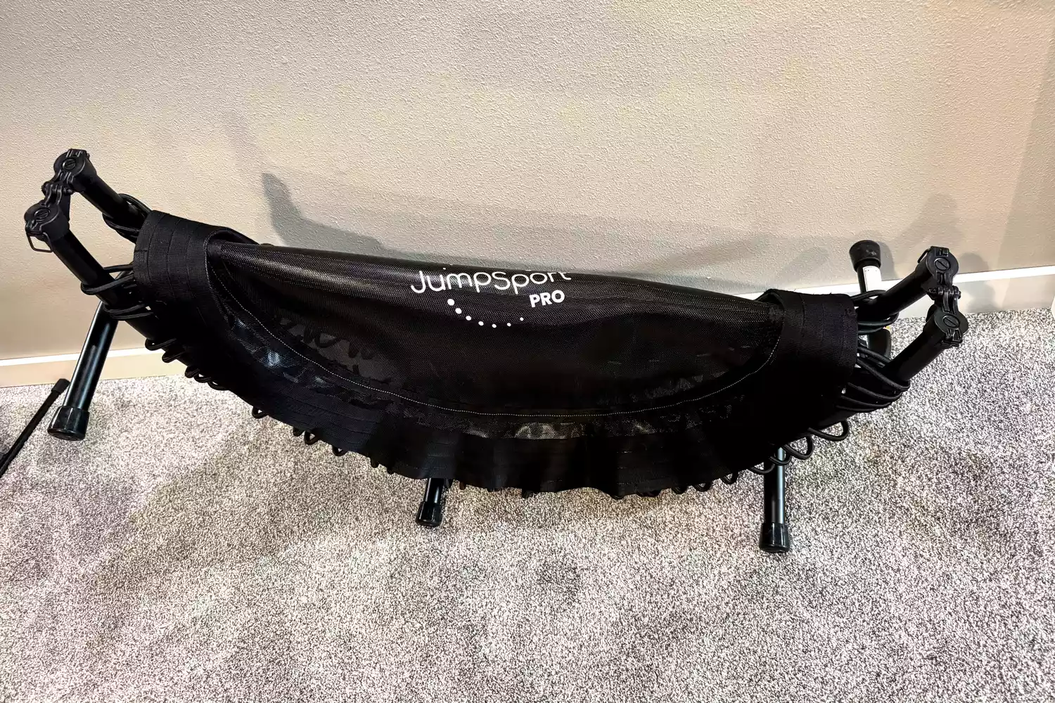 The JumpSport 550f 44-Inch Pro Rebounder Trampoline folded on white carpet