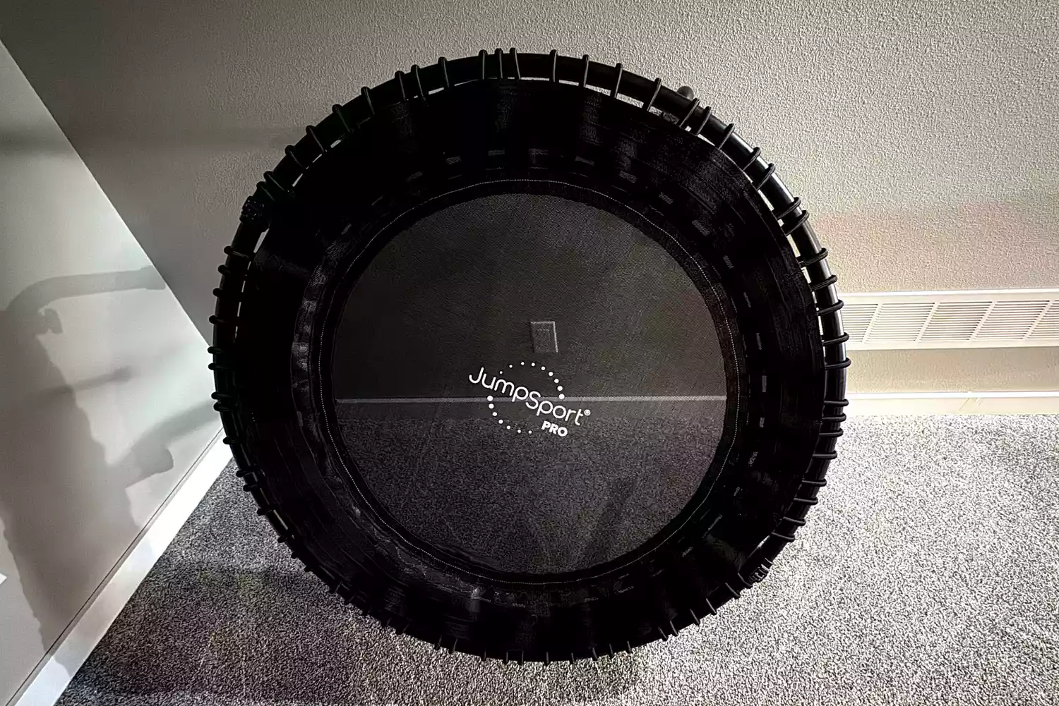The JumpSport 550f 44-Inch Pro Rebounder Trampoline leans against a wall