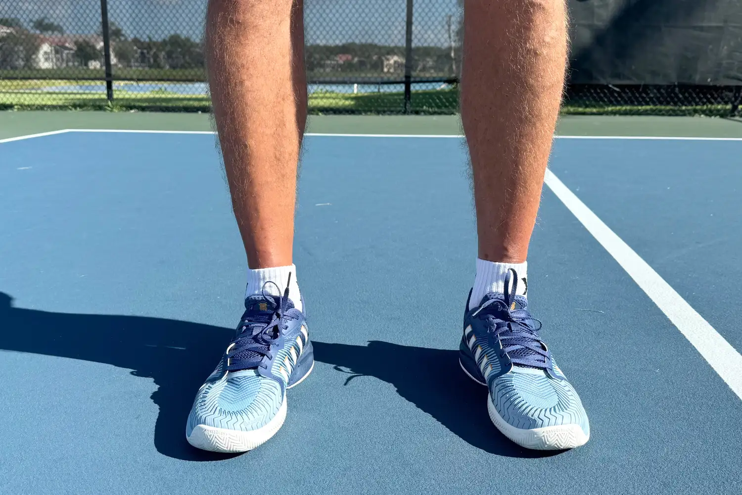 A front view of a person wearing the K-Swiss Men's Pickleball Supreme Shoe on a pickleball court