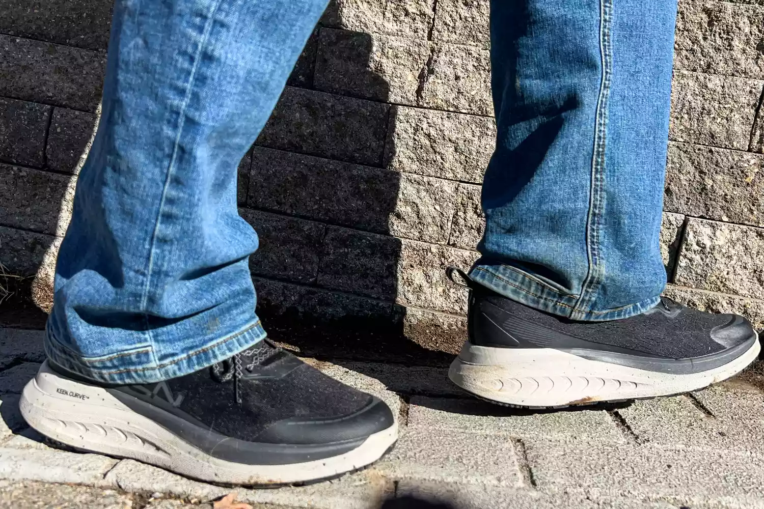 A close-up of two feet posed in the Keen Men's WK400 II Walking Shoes on stone tiles
