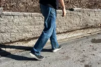 A close-up of legs walking on a road in the Keen Men's WK400 II Walking Shoe