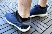 A person slips their heel out of the Kizik Men's Athens 2 Slip-On Shoes