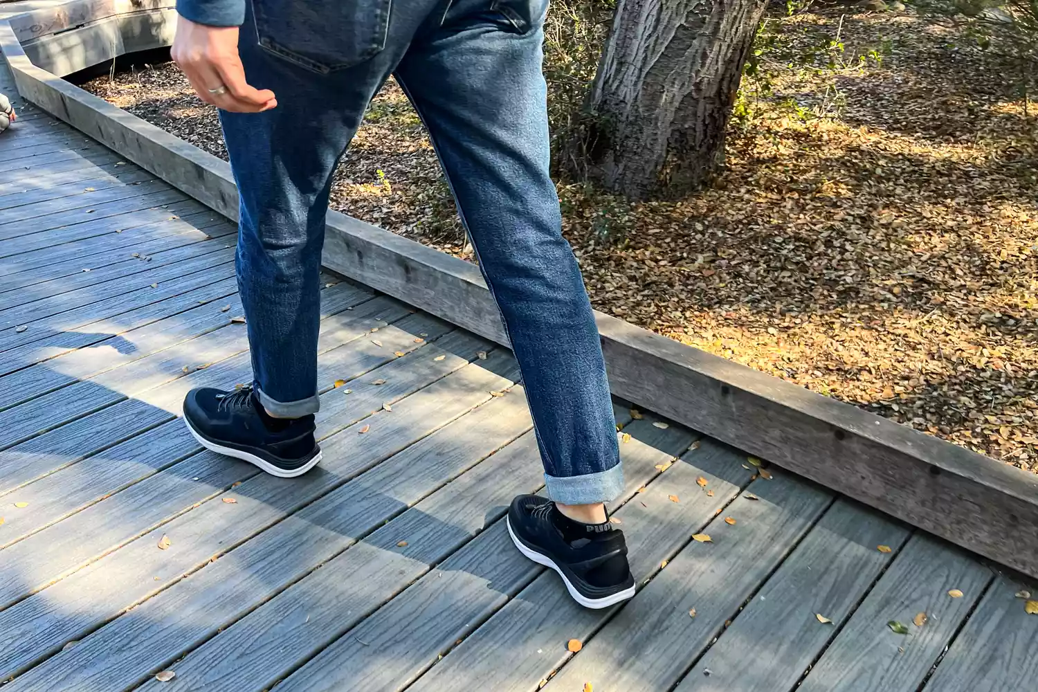A person walking on wood while wearing the Kizik Men's London sneakers
