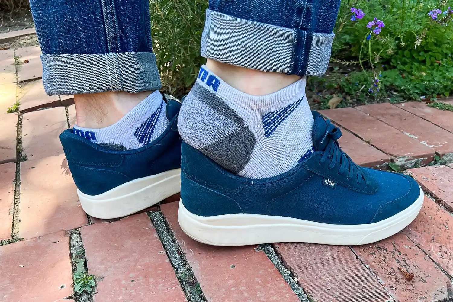 A person slips their heel out of the Kizik Men's Prague 2 Sneakers