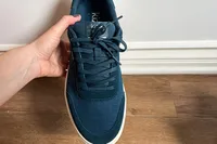 A person holds up the Kizik Men's Prague 2 Sneaker