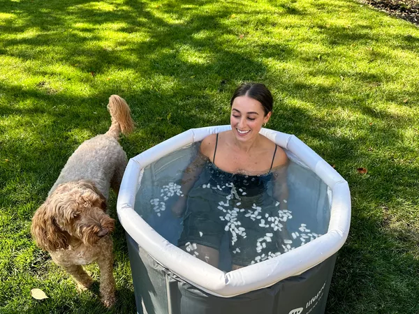 A person sitting in the Lifepro Allevachill Recovery Ice Tub