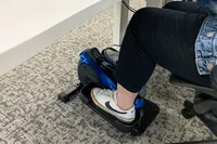 A person with their foot on the LifePro FlexStride Plus