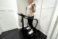 A person uses the resistance arm bands on the Lifepro Rhythm Vibration Plate